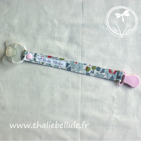 Attache tétine à fleurs bleues style liberty en tissu coton, avec une pince plastique rose