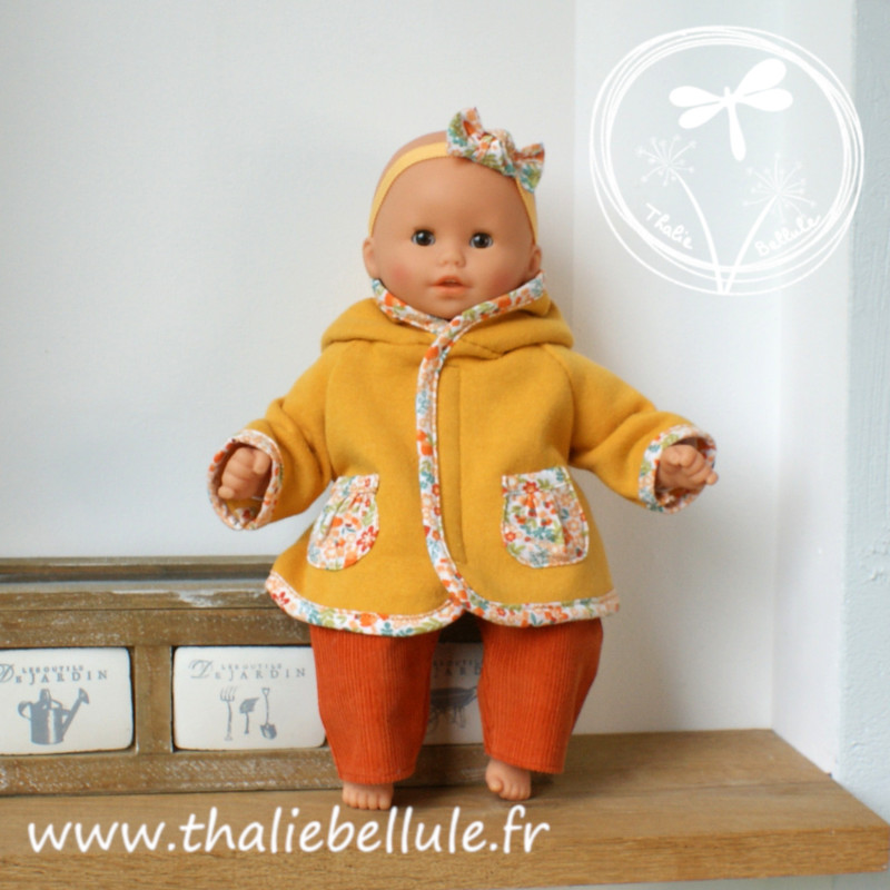 Manteau moutarde orné de biais et de poches à petites fleurs oranges pour poupon 30 cm, avec t-shirt et pantalon assortis Manteau moutarde orné de biais et de poches à petites fleurs oranges pour poupon 30 cm, avec t-shirt et pantalon assortis